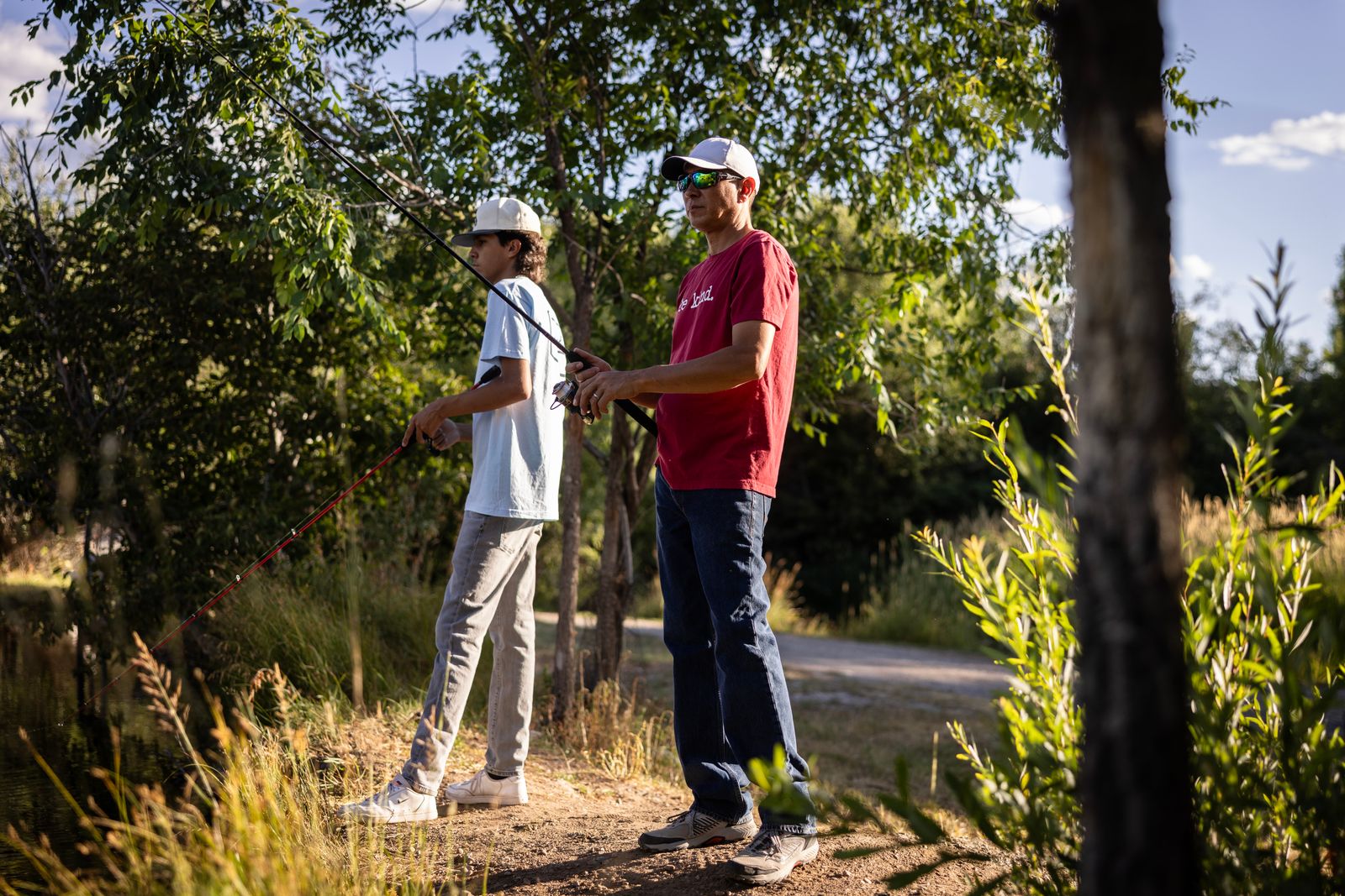 Two guests fishing together beside the pond at golden hour at Outdoorsy Bayfield